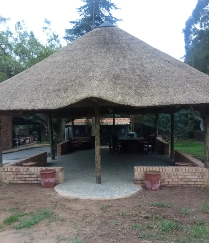 Die groot ronde grasdak-lapa met halfhoogte baksteenmure